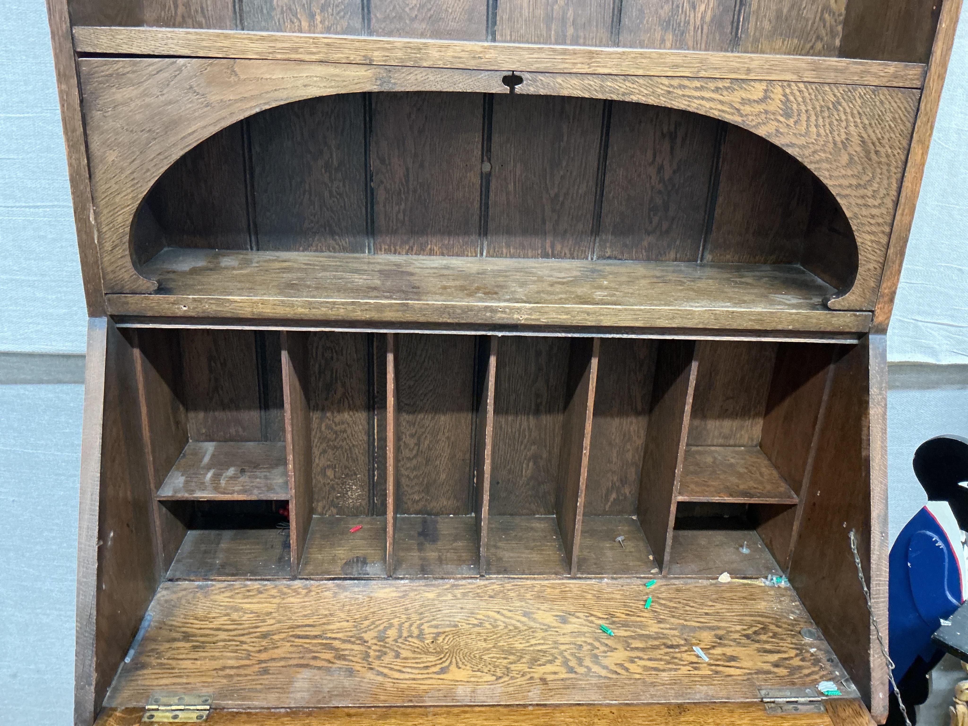 An Arts and Crafts brass mounted oak bureau bookcase, width 84cm, depth 38cm, height 185cm. Condition - fair